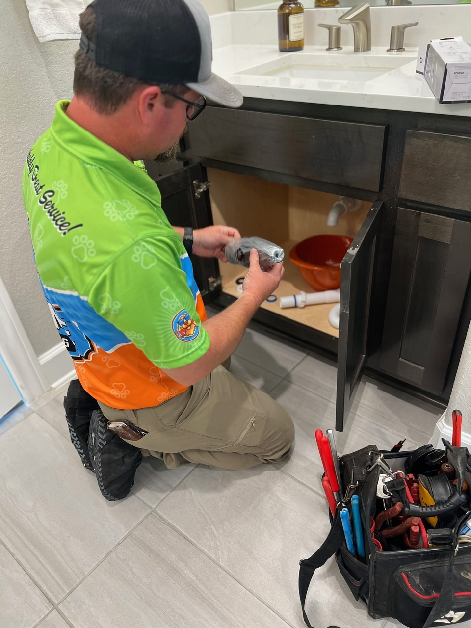 An image of a person working on a plumber under the sink